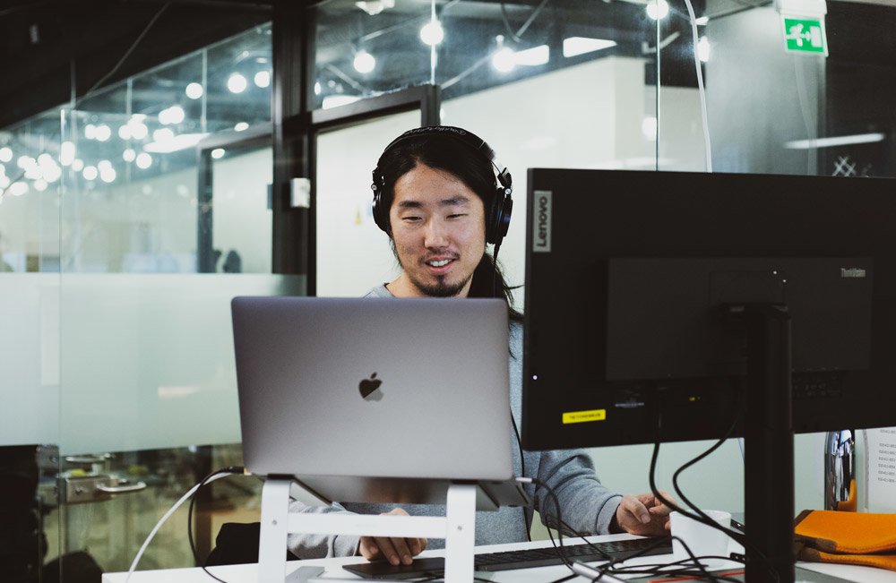 ihminen kahden näytön äärellä